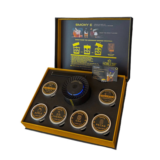 Smoky E cocktail kit with various components in a black and gold box on a dark background